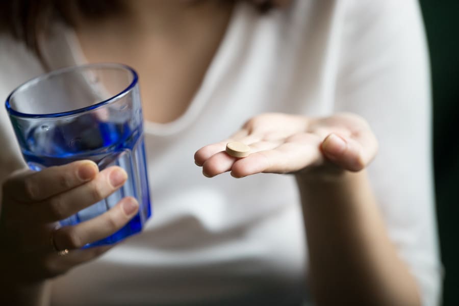 female-hands-holding-pill-glass-water-closeup-view (1).jpeg